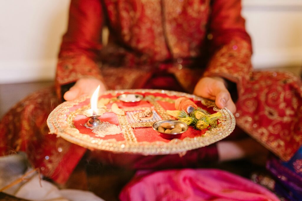 Close-up of a decorated puja thali with a lit diya, symbolizing Diwali celebrations.